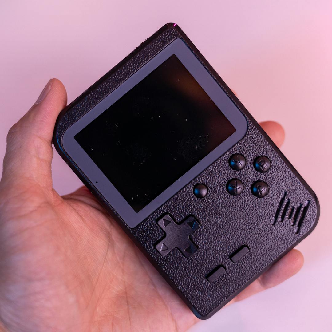 hand holding black retro handheld console