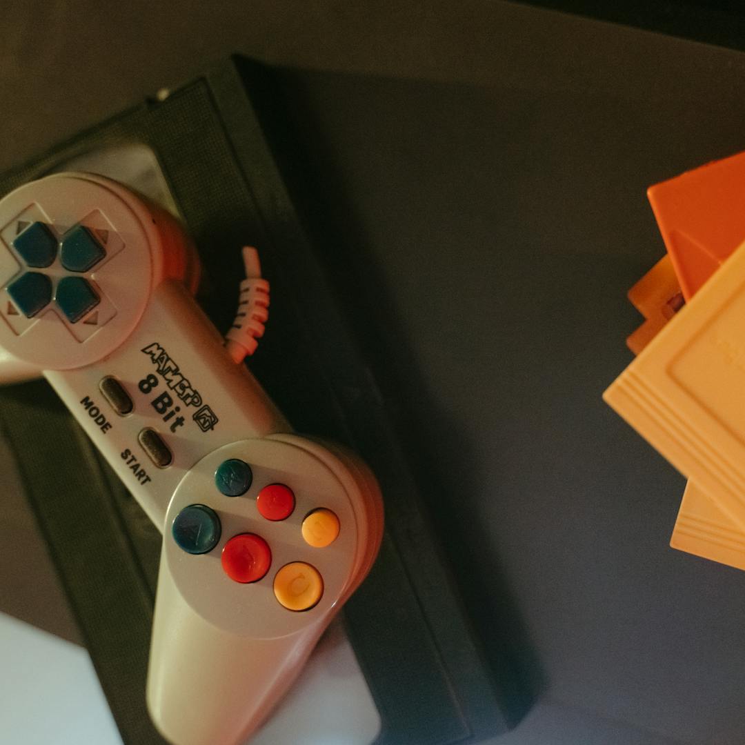 vintage 8-bit controller next to game cartridges