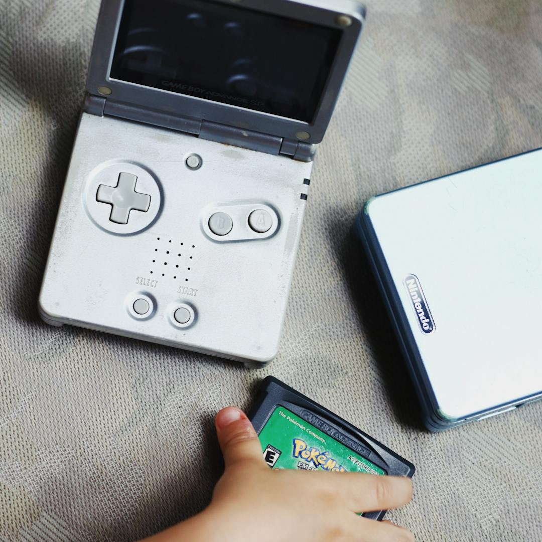 child holding vintage Game Boy with cartridge