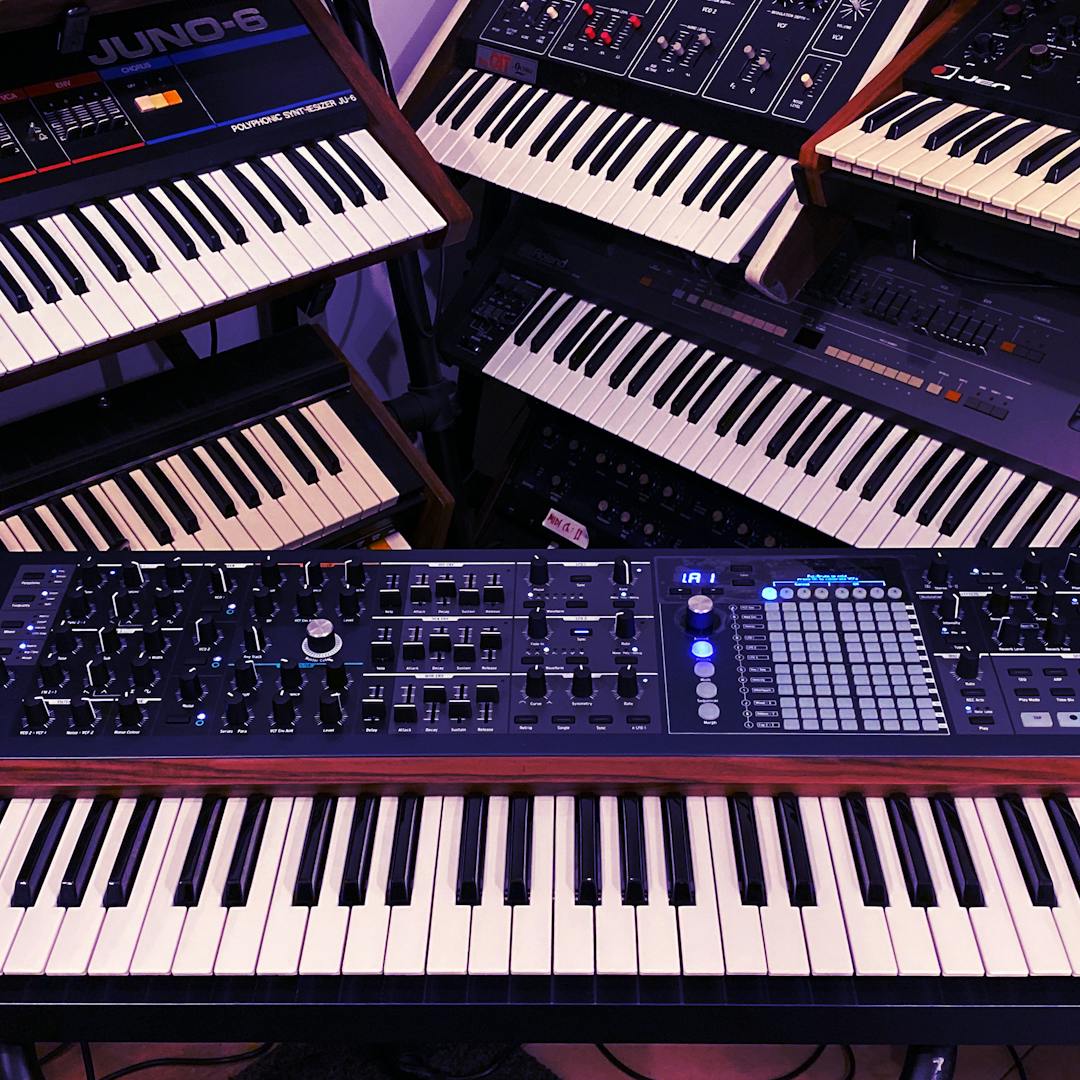 collection of vintage and modern synthesizers in studio